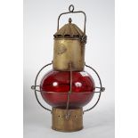 An early 20th century nautical brass ships onion shaped lantern. Having red glass onion shade,