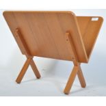 A 1970's teak wood Danish magazine rack of angular form raised on squared supports in the manner