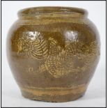 An early oriental brown stoneware jar depicting dr