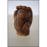 A Japanese carved wooden netsuke in the form of a