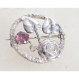 A vintage silver shield brooch with central flower