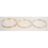 A group of three vintage rolled gold bangles two b