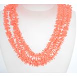 A vintage 1950s faux coral plastic three strand ne