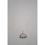 A silver pendant necklace strung with a silver bal