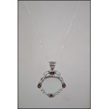 A silver and garnet magnifying glass on chain, cas