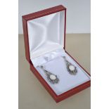 A pair of Art Deco style earrings set with a centr