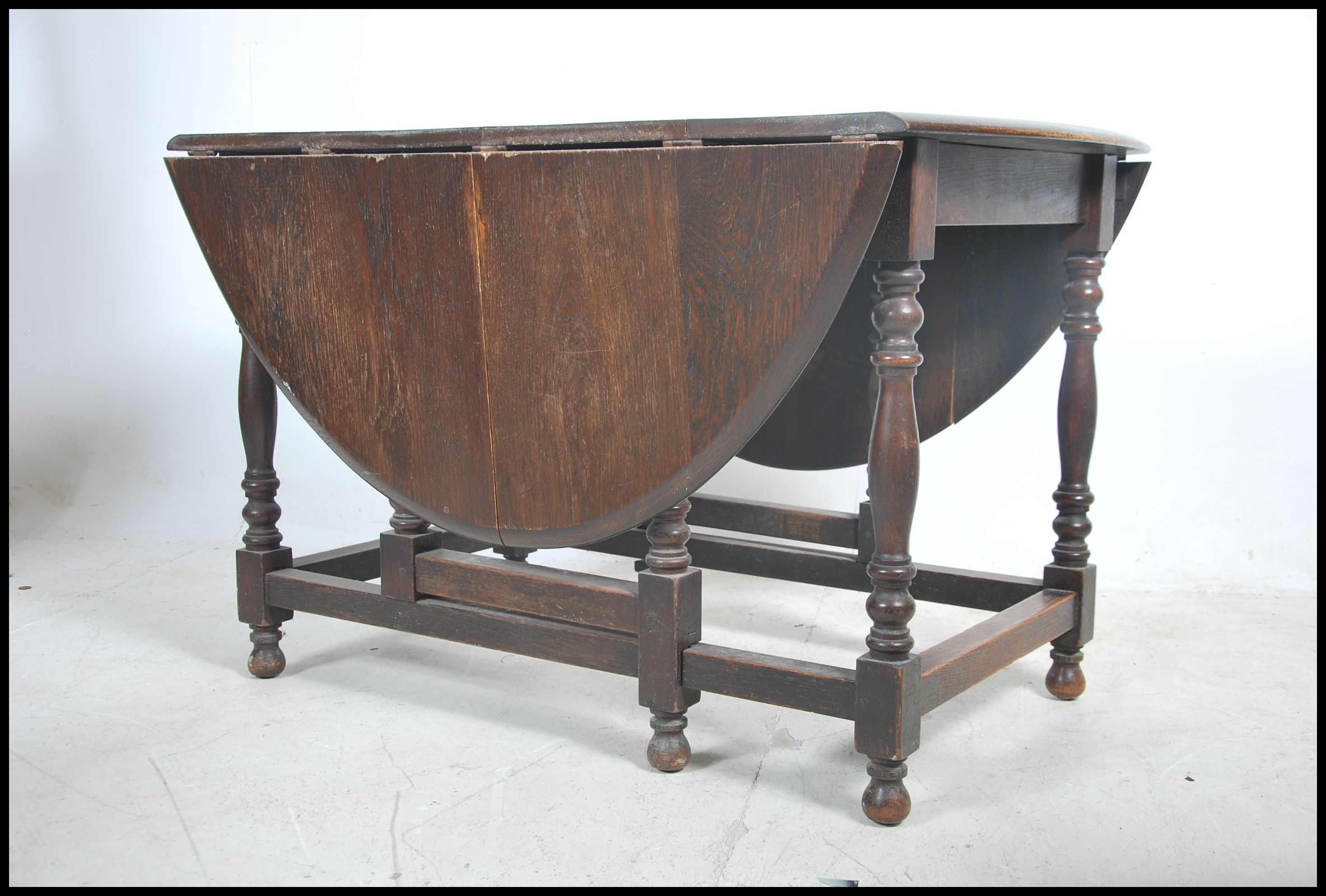 A 1930's large solid oak gateleg dining table. The