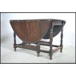 A 1930's large solid oak gateleg dining table. The