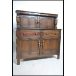 A 20th century Ercol court cupboard in beech and e