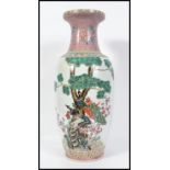 A large 20th century floor standing vase decorated heavily with birds of paradise. Measures 62cm