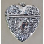 A silver heart shaped locket of decorative form co