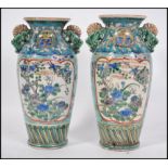 A pair of 19th / 20th century Chinese famille rose hand painted vases on blue ground with foliate