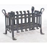 A 20th century ebonised wrought iron open fire grate of basket weave form, with angled feet