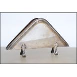 A continental stamped 800 silver letter rack of triangular form, geometric border raised on four pad