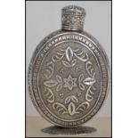A silver lidded perfume bottle having a screw top lid with floral and leaf decoration and border