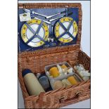 A retro vintage 20th century wicker picnic hamper with hinged lid opening to reveal a fitted