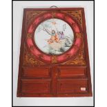 A 20th century Chinese ceramic circular plaque decorated in enamels with garden figural scene and