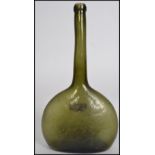 An 18th /19th century green glass bottle with unusual tall neck having onion shaped thin base.