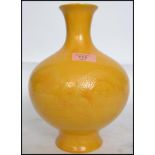 A 19th century Chinese yellow monochrome glaze vase of baluster form being decorated with dragons