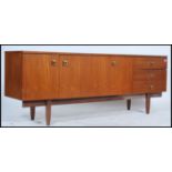 A 1970's retro Danish style teak wood sideboard raised on shaped supports with a series of cupboards