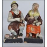 A pair of 19th Century Staffordshire pottery figures of the Cobbler and his wife on square bases.