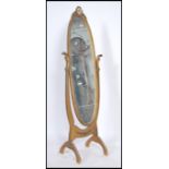 A 1950's mid century gilt rococo cheval mirror having an elongated oval swing mirror being raised on