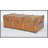 A vintage 20th century canvas and wooden bound steamer trunk having three lock catches to front with