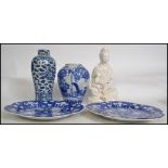 A Chinese Blanc De Chine deity porcelain glazed figurine with seated child. Together with 2 blue and