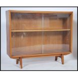 A 1970's Herbert Gibbs teak wood glass sliding door window bookcase with inset shelves and on