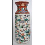 A 19th Chinese famille verte vase being decorated with phoenix and foliates with waisted neck in