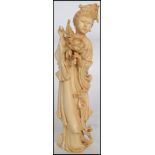 A Late 19th Early 20th Century Chinese Carved Ivory Figure in the form of a girl holding flowers.