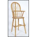 A Victorian style country pine childs high chair raised on turned legs united by stretchers having