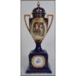 A 19th century Continental twin handled ceramic lidded urn, on cobalt blue ground with central panel