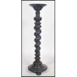 An early 20th century Edwardian tall ebonised tourchere / plant stand of baley twist form having