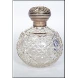 A silver hallmarked ladies perfume bottle having globular cut glass body with rococo silver top