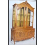 A large French 20th century oak vitrine display cabinet. Raised on shaped cabriole legs with cabinet