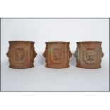 A set of 3 19th century cast iron cylindrical plant pots / planters each with lion mask decoration