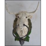 A vintage style cast iron cows /  bull head mounted on a naturalistic wreath armorial shield