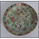 A 19th century Chinese celadon charger / dish, decorated in famille rose colours with butterflies