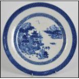 An 18th / 19th century Chinese blue and white ceramic plate in the willow pattern with scenes of