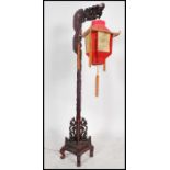 An unusual mid century Chinese hardwood dragon standard lamp having a carved details column with