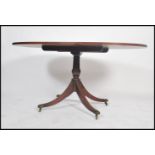 A Regency style walnut and mahogany oval breakfast / loo tilt top dining table. The crossbanded oval