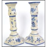A pair of believed 19th century Delft blue and white candlesticks having bird and foliate