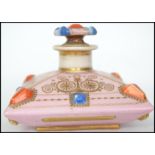 A 19th century Continental ceramic perfume bottle with fitted stopper. In the form of a bejewelled