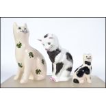 A group of three Wemyss ceramic cat figurines to include Compton and Wood house example and two G