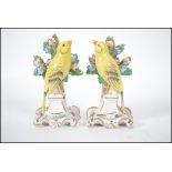 A true pair of 20th century believed Dresden / Meissen ceramic canaries on pedestal bases in front