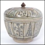 A believed 16th / 17th century Oriental stoneware lidded jar with finial atop. Measures 13cms wide.
