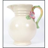 A vintage 20th century Art Deco Clarice Cliff for Newport  tall pottery jug with floral handle,