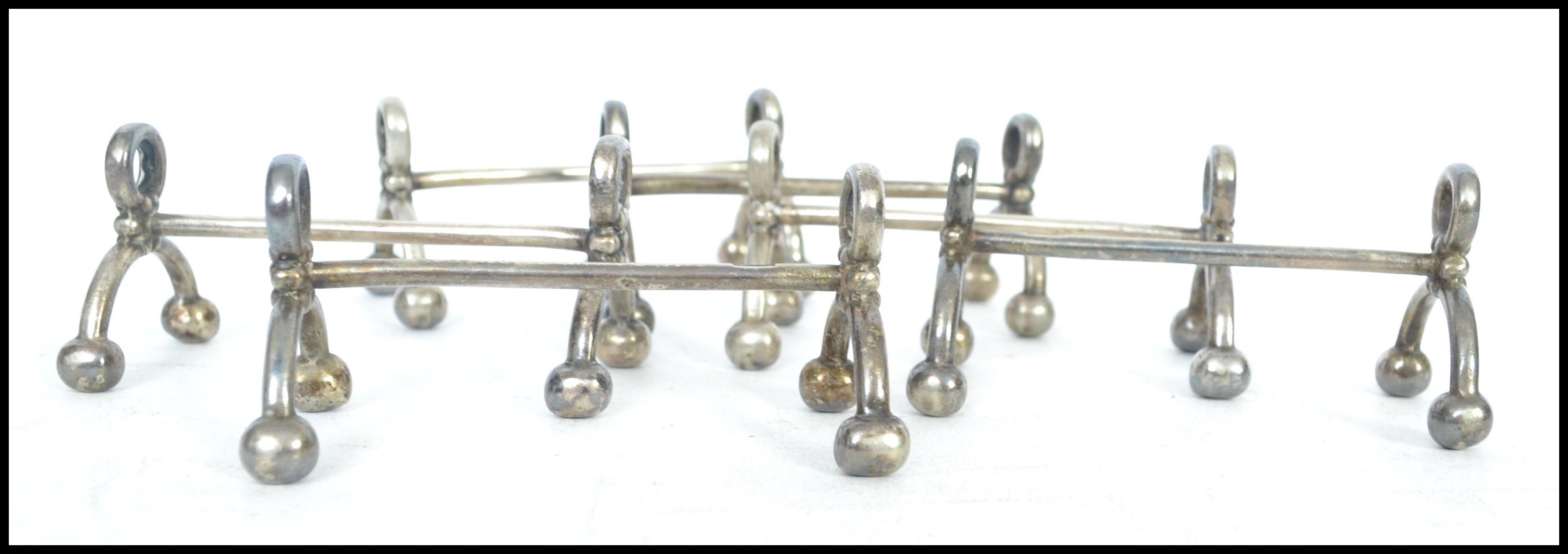 A set of silver plated knife rests having bow legs