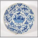 An 18th century delft charger in blue and white ha